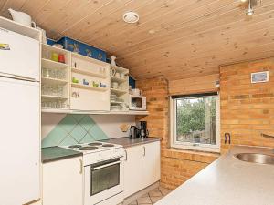 灵克宾7 person holiday home in Ringk bing的一间厨房,配有白色家电和砖墙
