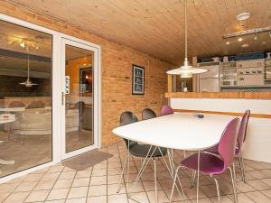 灵克宾7 person holiday home in Ringk bing的一间设有白色桌子和紫色椅子的用餐室