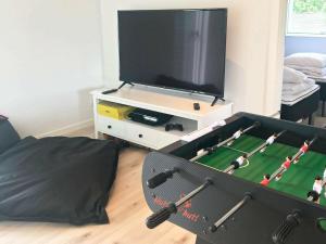 博托比14 person holiday home in V ggerl se的客厅配有电视和带玩具足球游戏的桌子。