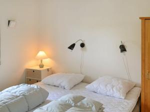 布拉万德Holiday Home Horns Bjerge IV的卧室内的两张床,墙上有两盏灯