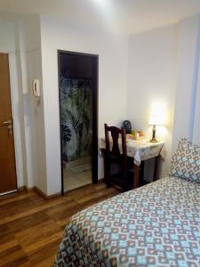 圣卡洛斯-德巴里洛切Astoria Patagonia II habitaciones privadas的一间卧室配有一张床、一张桌子和一张桌子