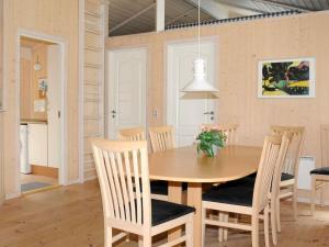 奥克斯伯尔Three-Bedroom Holiday home in Oksbøl 17的厨房以及带木桌和椅子的用餐室。