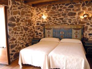 Barbadillo del PezHostal Residencia El Mirador del Pedroso的卧室配有一张石墙床
