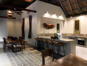 洛斯纳兰霍斯Casa Bambu Tayrona, Los Naranjos的厨房设有酒吧,配有一些桌椅