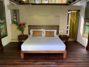 洛斯纳兰霍斯Casa Bambu Tayrona, Los Naranjos的卧室配有一张带白色床单和枕头的大床。