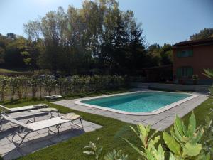 MarcoianoLa Casetta的一个带椅子的庭院和房子的游泳池