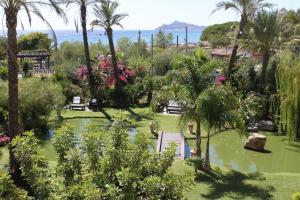 圣玛丽亚纳瓦雷地中海酒店的种有棕榈树和水体的花园