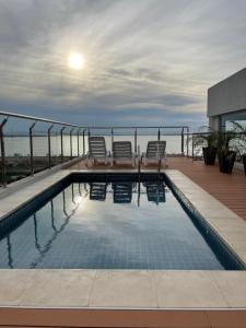 恩卡纳西翁Monoambiente a 400 metros de la playa的建筑物屋顶上的游泳池