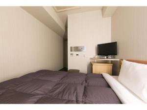 名古屋R&B HOTEL NAGOYA SAKAE HIGASHI - Vacation STAY 14030v的一间卧室配有一张床和一台平面电视