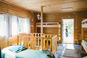 RiihoRiihon Majatalo的卧室设有木墙和一张双层床。