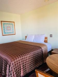 LulingCoachway Inn的酒店客房配有一张床铺和一张桌子。