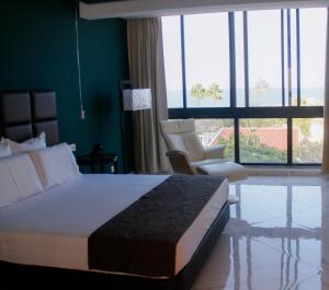 塔拉法尔Hotel Por Do Sol的一间卧室配有床和椅子以及大窗户
