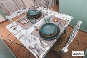 维泰博CHAPLIN Luxury Holiday House的桌子上摆着盘子和餐具