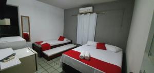 塔曼达雷Hotel Pousada Mar Azul的小房间设有两张床和镜子