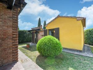 阿夸维瓦Belvilla by OYO Chiaradue的前面有灌木的黄色房子