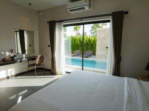 洛坤府Toledo Pool Villa的一间卧室配有一张床,享有游泳池的景色