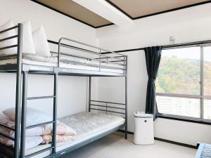 伊东荘荘旅馆的一间卧室设有两张双层床和一扇窗户。