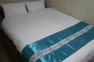淡路民泊 桔梗的白色的床,配有蓝色和白色的床单和枕头