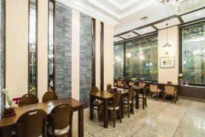 安山市奥拉酒店的餐厅设有桌椅和窗户。