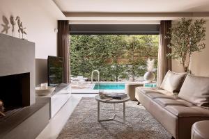 雅典Elaia Luxury Condo Glyfada的带沙发和电视的客厅以及游泳池。