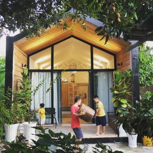 Tây NinhMoon Garden Homestay - cozy cabin and natural pool in Tay Ninh的站在房子前面的男人和两个男孩