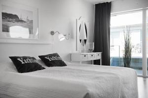 王室港Hotell Kungshamn Suites的白色卧室配有一张带两个枕头的大床