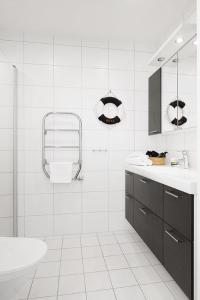 王室港Hotell Kungshamn Suites的白色的浴室设有水槽和淋浴。