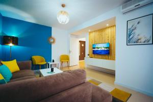 马赫穆迪亚Vero Holiday Apartment的客厅设有棕色沙发和蓝色的墙壁