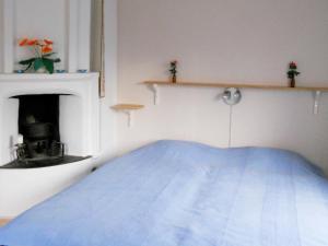 Agunnaryd6 person holiday home in RYSSBY的一间卧室设有一张蓝色的床和壁炉