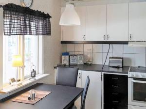 博尔奈斯Holiday home BOLLNÄS的厨房配有白色橱柜、桌子和窗户。