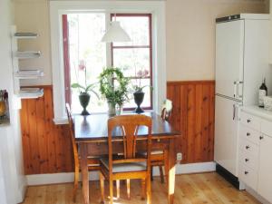 Glanshammar6 person holiday home in GLANSHAMMAR的厨房配有木桌、椅子和窗户