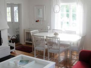 Glanshammar6 person holiday home in GLANSHAMMAR的白色的用餐室配有桌椅