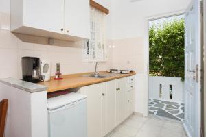 德里奥斯贝蒂公寓酒店的厨房配有白色橱柜、水槽和窗户。