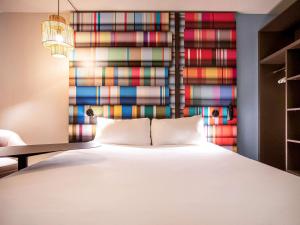 佩皮尼昂ibis Styles Perpignan Centre Gare的一间卧室设有一张床和色彩缤纷的墙壁