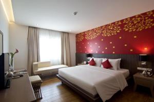 乔木提恩海滩芭堤雅乔木提恩特万酒店的一间卧室设有一张大床和红色的墙壁