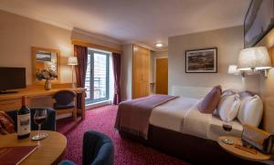 克利夫登克利夫登站酒店的配有一张床和一张书桌的酒店客房