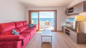 卡莱利亚德帕拉弗鲁赫尔Voramar B的客厅配有红色沙发,享有海景