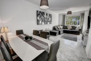 贝纳尔马德纳TIMON II, Luxury 3 bedroom Beachside Apartment的厨房以及带桌椅的起居室。