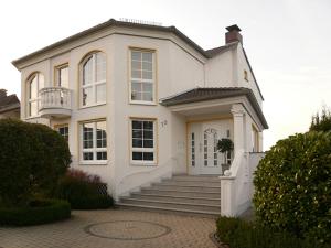 卡塞尔Ferienwohnungen Damm的一座带楼梯和门廊的大型白色房屋