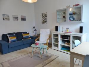 奥瑟戈尔Villa Mitoyenne Pour 4 Personnes Proche Centre-Ville D hossegor的客厅配有蓝色的沙发和桌子