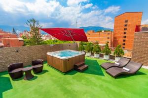 麦德林奥博酒店的草坪上的热水浴池配有椅子和遮阳伞
