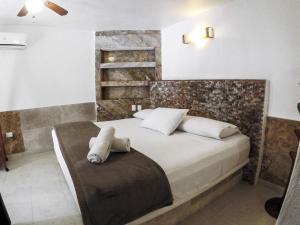 奇琴伊察卡萨鲁乃旅馆的卧室配有带白色枕头的大床