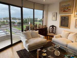 萨尔塔DEPARTAMENTO PREMIUM - 2 HAB. Y 2 BAÑOS的客厅配有2张白色沙发和大窗户
