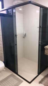 伊瓜苏Studio Julio Cezar的一间带卫生间的浴室内的玻璃淋浴间