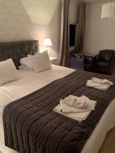 亨尼博斯特兰德Hotell Kaprifol的一间卧室配有一张床,上面有两条毛巾