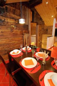 采尔马特Ferienapartement Hinterdorf的用餐室配有木桌、盘子和玻璃杯