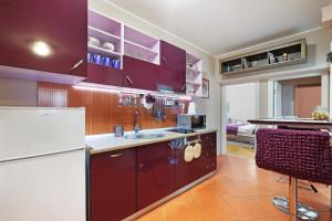 贝尔格莱德Sava SQUARE Apartment的厨房配有紫色橱柜和白色冰箱