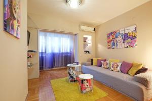 贝尔格莱德Sava SQUARE Apartment的客厅配有沙发和墙上的绘画