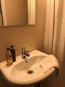 亨尼博斯特兰德Hotell Kaprifol的浴室设有白色水槽和镜子
