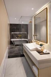 雅加达Sutasoma Hotel的浴室配有盥洗盆和浴缸。